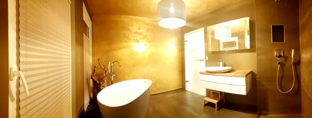 Badezimmer mit Wanne und Waschbecken in goldenem Licht