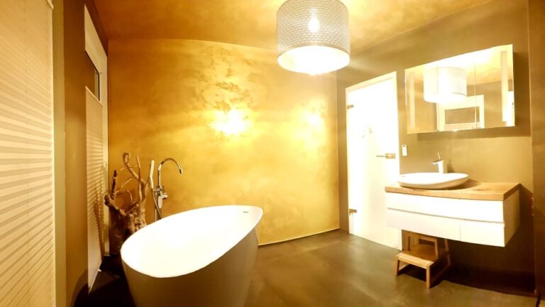 Badezimmer mit Wanne und Waschbecken in goldenem Licht